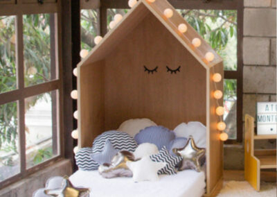 wooden headboard in the shape of a house for a child's bed